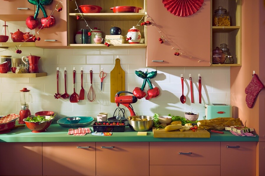 Kitchen counter with food prep, red utensils, fairy lights, and inflatable cherries all hung neatly using Command Hooks.
